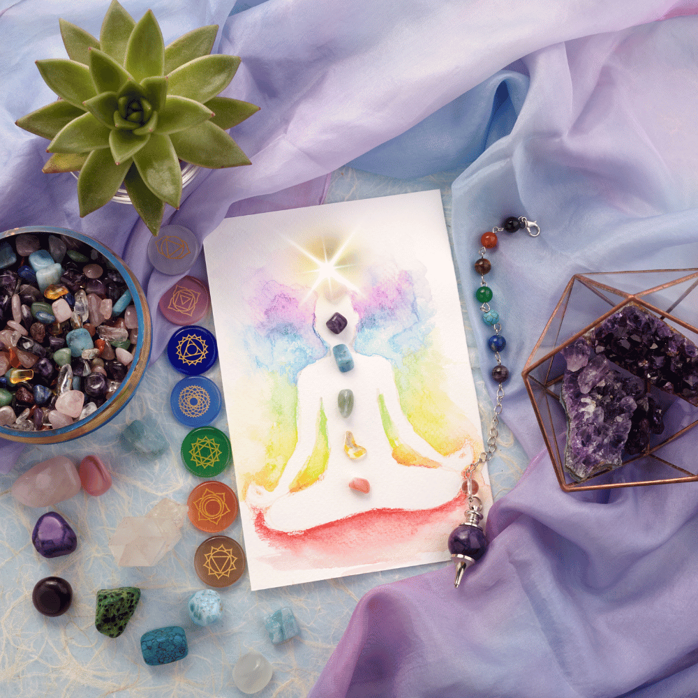 purple fabric with a water coloring of the 7 main chakras with crystals all around it